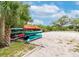 Community canoe storage area with multiple canoes stacked on a sandy beach at 5802 Hatteras Palm Way, Tampa, FL 33615