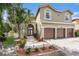 Charming two-story home with a three-car garage, beautiful landscaping, and a tile roof at 5802 Hatteras Palm Way, Tampa, FL 33615