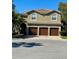 Charming two-story home with a tile roof, three-car garage, and mature landscaping at 5802 Hatteras Palm Way, Tampa, FL 33615
