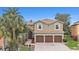 Spacious two-story home featuring a three-car garage, a tile roof, and a paver driveway at 5802 Hatteras Palm Way, Tampa, FL 33615