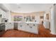 Bright kitchen boasts white cabinetry, stainless steel appliances, quartz countertops, and wood flooring at 5802 Hatteras Palm Way, Tampa, FL 33615