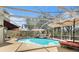 Enclosed swimming pool area with lounge chairs and lush backyard at 5802 Hatteras Palm Way, Tampa, FL 33615