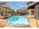 Private screened-in pool area featuring patio furniture, barbecue, and lounge chairs at 5802 Hatteras Palm Way, Tampa, FL 33615