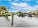 Scenic waterfront view featuring boat docks and lush landscaping under a bright blue, partly cloudy sky at 5802 Hatteras Palm Way, Tampa, FL 33615