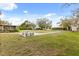 Spacious backyard with mature trees, concrete patio and swing set at 12205 Kelly Ln, Thonotosassa, FL 33592