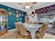 Dining room with blue accent wall, eclectic decor, screened windows, and seating for six at 12205 Kelly Ln, Thonotosassa, FL 33592