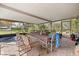 Covered patio with tile floor, table, hot tub and view of the back yard at 12205 Kelly Ln, Thonotosassa, FL 33592
