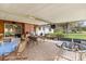 Covered patio with tile floor, table, hot tub and view of the back yard at 12205 Kelly Ln, Thonotosassa, FL 33592