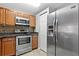 Well-equipped kitchen with stainless steel refrigerator and oven and wooden cabinets at 15215 Amberly Dr # 1004, Tampa, FL 33647