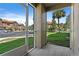 Enclosed porch with views of the street, lush green grass, palm trees, and neighboring buildings, creating a serene outdoor space at 15215 Amberly Dr # 1004, Tampa, FL 33647