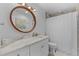 Bathroom featuring a large round mirror, white vanity, and a shower with white shower curtain at 1767 Colorado Ne Ave, St Petersburg, FL 33703