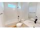 Bright bathroom featuring a white tub, shower, toilet, and single sink with black fixtures at 3603 Lajuana Blvd, Wesley Chapel, FL 33543
