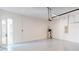 A spacious two car garage with gray epoxy flooring and side door at 3603 Lajuana Blvd, Wesley Chapel, FL 33543