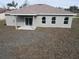 An exterior view of the back of the house featuring a sliding glass door and three windows at 383 Yeager St, Port Charlotte, FL 33954