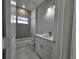 Stylish bathroom featuring gray tiling, a large mirror, a shower, and modern fixtures at 383 Yeager St, Port Charlotte, FL 33954