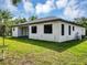 A modern white stucco home has a rear patio with black trim windows at 82 Venango St, Port Charlotte, FL 33954