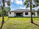 A modern home boasts a well-manicured lawn and a sleek, black-framed sliding glass door at 82 Venango St, Port Charlotte, FL 33954