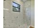 Modern bathroom shower featuring marble-patterned tile and a bright window at 82 Venango St, Port Charlotte, FL 33954