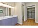 Bathroom featuring double sink vanity with modern lighting and an open closet with wood floor at 82 Venango St, Port Charlotte, FL 33954