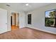 Bedroom with wood flooring, two windows and a doorway leading to the bathroom at 82 Venango St, Port Charlotte, FL 33954