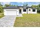 Charming single-Gathering home featuring a two-car garage, manicured lawn, and stylish exterior finishes at 82 Venango St, Port Charlotte, FL 33954