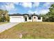 Elegant single-Gathering home with a two-car garage, and a well-maintained front yard on a sunny day at 82 Venango St, Port Charlotte, FL 33954