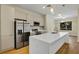 Modern kitchen featuring stainless steel appliances, a large island, and stylish pendant lighting at 82 Venango St, Port Charlotte, FL 33954