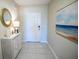 Bright entryway featuring neutral walls, tile flooring, and an accent table with beach themed decor at 5048 Silver Bell Dr, Port Charlotte, FL 33948