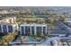 Community aerial view featuring a pool, clubhouse, manicured landscaping, parking, and views of nearby waterways at 1000 Cove Cay Dr # 5E, Clearwater, FL 33760