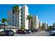 A low angle exterior view of the condos showcasing the parking area and palm trees at 1000 Cove Cay Dr # 5E, Clearwater, FL 33760