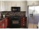 Kitchen featuring stainless steel refrigerator, range, microwave, granite counters and tiled backsplash at 1000 Cove Cay Dr # 5E, Clearwater, FL 33760