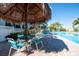 Relaxing poolside area with shade under tiki hut at 1000 Cove Cay Dr # 5E, Clearwater, FL 33760