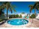 Secluded backyard with inviting small round pool, brick pavers, privacy fence, and palm trees at 1000 Cove Cay Dr # 5E, Clearwater, FL 33760