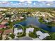 Aerial view of home with stunning lake view surrounded by lush landscaping in a beautiful neighborhood at 1727 Waxwing Cir, Venice, FL 34293