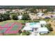 An aerial view showcasing tennis courts, a community pool, and residential homes at 1727 Waxwing Cir, Venice, FL 34293