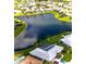 Aerial view of a beautiful lakefront home with a screened-in pool and meticulously landscaped backyard at 1727 Waxwing Cir, Venice, FL 34293