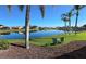 Peaceful backyard featuring a meticulously maintained lawn leading to a serene lake view at 1727 Waxwing Cir, Venice, FL 34293