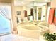 Bathroom featuring a tiled floor, soaking tub, and lots of counter space at 1727 Waxwing Cir, Venice, FL 34293