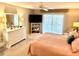 Bedroom with a large window, plush bed, television, and a chest of drawers at 1727 Waxwing Cir, Venice, FL 34293