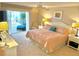 Cozy bedroom with a pink comforter on a plush bed, and access to a screened lanai at 1727 Waxwing Cir, Venice, FL 34293