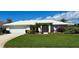 Charming home with a lush green lawn, complemented by colorful flowers and an oversized two car garage at 1727 Waxwing Cir, Venice, FL 34293