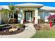 A welcoming front entrance with a stone walkway, lovely landscaping, and comfortable outdoor seating at 1727 Waxwing Cir, Venice, FL 34293