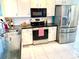 Kitchen featuring stainless steel appliances, white cabinetry, and dark countertops at 1727 Waxwing Cir, Venice, FL 34293