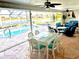 Enclosed lanai offers a dining and living space with a view of the pool and lake at 1727 Waxwing Cir, Venice, FL 34293
