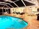 Backyard pool with a screened-in patio and various seating areas, creating an inviting outdoor living space at 1727 Waxwing Cir, Venice, FL 34293