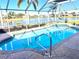 Screened-in pool with chairs overlooking the beautiful lake and meticulously manicured lawn and landscaping at 1727 Waxwing Cir, Venice, FL 34293