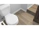 Close-up of a toilet in a bathroom with light wood-look floors and white baseboards at 3305 Acapulco Dr, Riverview, FL 33578