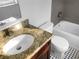 Bathroom with granite countertop, updated fixtures, a white toilet, and a tub with tile surround at 3305 Acapulco Dr, Riverview, FL 33578