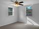 Sunlit bedroom featuring a ceiling fan, neutral walls, plush carpeting, and two windows offering neighborhood views at 3305 Acapulco Dr, Riverview, FL 33578