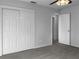 Bedroom featuring closet doors and an open door to another room, complemented by light-colored walls and carpet flooring at 3305 Acapulco Dr, Riverview, FL 33578